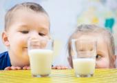To små barn som sammenligner innhold i et melkeglass